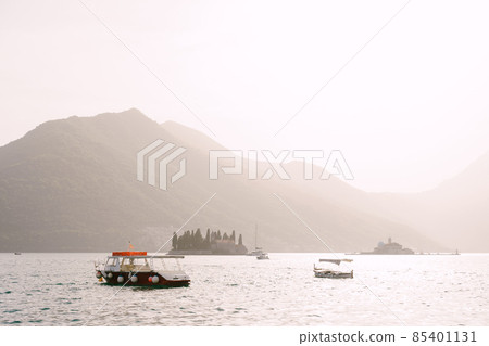 Pleasure boats sail past the islands of St. George and Gospa od Skrpjela in the Kotor Bay Pleasure boats sail past the islands of St. George and Gospa od Skrpjela in the Kotor Bay 85401131
