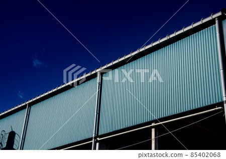 Brightly colored factory walls and blue sky 85402068