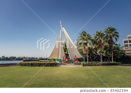 Shaded kid's playground activity tower equipment at park with a slide. 85402594