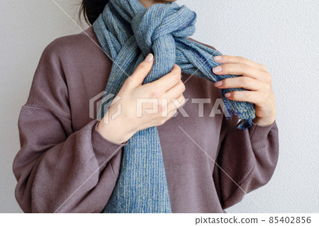 A woman in the middle of winding a muffler 85402856