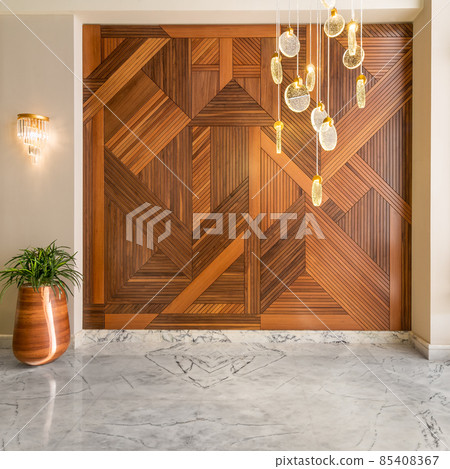 Wood cladding wall, tall planter with bushes, modern glass tall chandelier, and white marble floor Wood cladding wall, tall planter with bushes, modern glass tall chandelier, and white marble floor 85408367