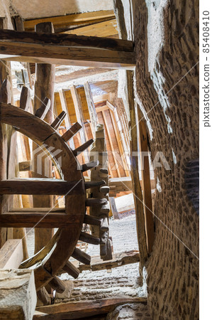 From below shot of aged water mill turning inside weathered mill building 85408410