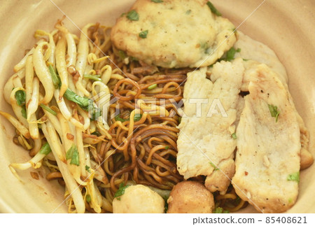 dry Chinese yellow egg noodles dressing black sweet soy sauce with slice pork and meatball with bean sprout in on bowl dry Chinese yellow egg noodles dressing black sweet soy sauce with slice pork and meatball with bean sprout in on bowl 85408621
