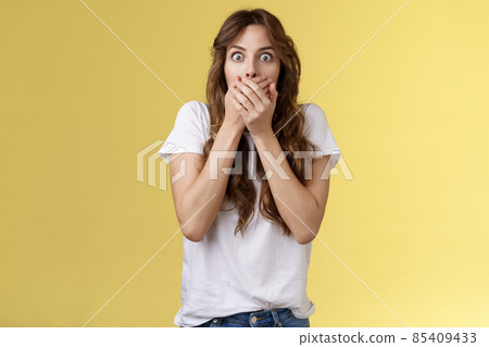 Shocked ambushed speechless cute girl hear impressive rumor shut mouth hold hands lips stare camera astonished eavesdrop juicy stunning conversation stand yellow background Shocked ambushed speechless cute girl hear impressive rumor shut mouth hold hands lips stare camera astonished eavesdrop juicy stunning conversation stand yellow background 85409433