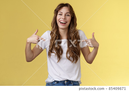 Haha awesome. Positive sincere attractive young woman curly long hair laughing joyfully pointing fingers center copy space white t-shirt chuckling having fun discuss great link show you promo 85409871