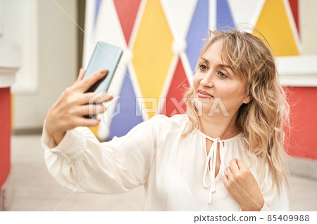 Young woman doing self portrait outside. City vacation portrait. Blogger selfie 85409988