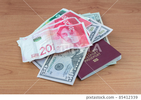 Polish biometric passport with United States dollar banknotes and Israeli new shekel banknotes. Polish biometric passport with United States dollar banknotes and Israeli new shekel banknotes. 85412339