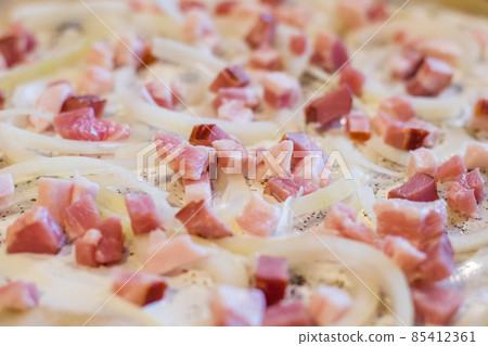 Close-up on onion and bacon on the top of flammkuchen. Close-up on onion and bacon on the top of flammkuchen. 85412361