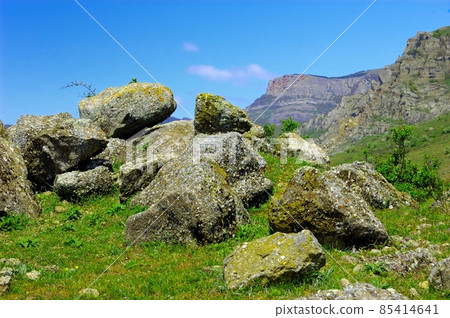 Horizontal background with a magnificent landscape of the Crimean Peninsula. Top view of the mountains covered with lush greenery and the thick clouds below the peaks. Clear blue sky. Copy space. 85414641