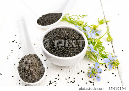 Seeds of black cumin in bowl on light board Seeds of black cumin in bowl on light board 85419194