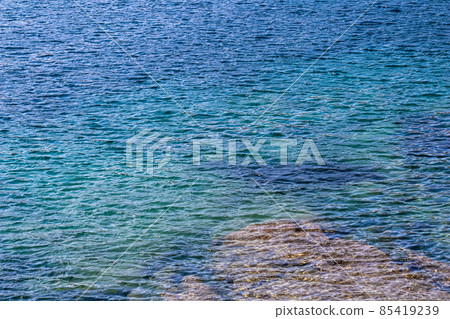 Blue sea waves in sunshine glow as surface background. Summer holidays and coastal nature concept 85419239