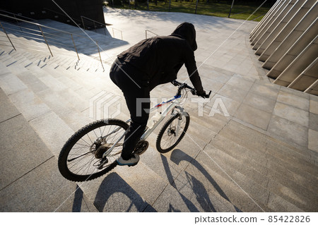 Woman free rider riding bike going down city stairs 85422826