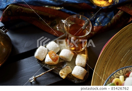 Black Turkish tea in lale with oriental sweets and dried fruits by candlelight Black Turkish tea in lale with oriental sweets and dried fruits by candlelight 85426762