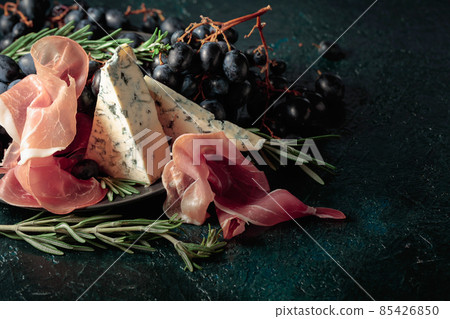 Prosciutto with blue cheese, grapes, and rosemary. Prosciutto with blue cheese, grapes, and rosemary. 85426850