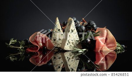Prosciutto with blue cheese, grapes, and rosemary. Prosciutto with blue cheese, grapes, and rosemary. 85426851