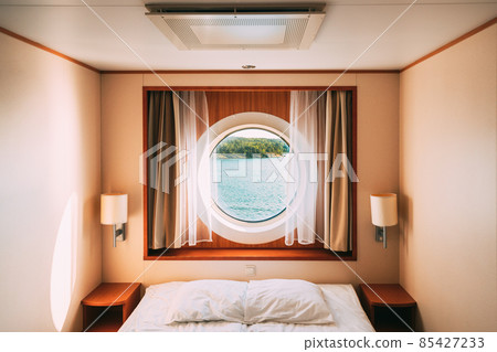 Ship Window In Craft Cabin With Bed. View On Sea. Luxury Cabin On Ferry Boat Or Cruise Liner. Sea Cruise Vacation Trip Travel Concept 85427233