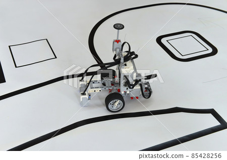Programmable robot with wheels driving on paper road. robotic car with obstacle line follow ability Programmable robot with wheels driving on paper road. robotic car with obstacle line follow ability 85428256