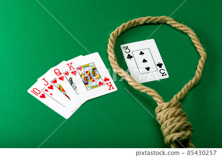 Playing cards on a green felt table with a rope in a loop, gambling addiction, debts Playing cards on a green felt table with a rope in a loop, gambling addiction, debts 85430257