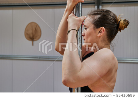 middle-aged woman lifestyle performing pole dancing exercises in a nice yoga studio middle-aged woman lifestyle performing pole dancing exercises in a nice yoga studio 85430699