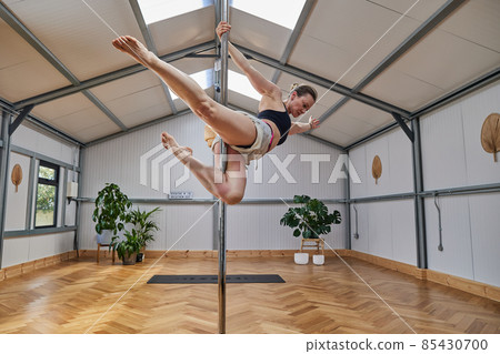 large pole dance studio with dancing instructura suspended in the air. large pole dance studio with dancing instructura suspended in the air. 85430700