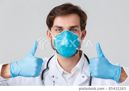 Hospital, healthcare workers, covid-19 treatment concept. Close-up shot of supportive, professional doctor fighting over coronavirus, wear gloves and medical respirator, thumb-up, approve something 85432263