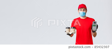 Takeaway, food and groceries delivery, covid-19 contactless orders concept. Excited and surprised client or employee in red uniform, face mask and gloves, giving client paying terminal with coffee 85432307