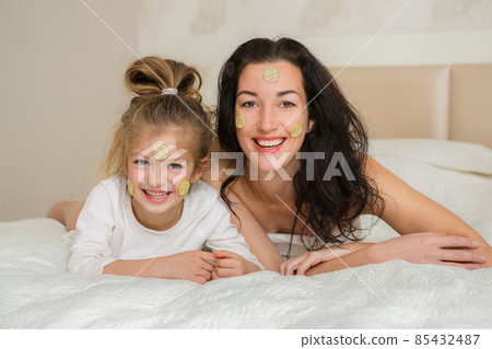 Mother and her daughter playing and hugging in the bed. Happy loving family. Happy mother's day. 85432487