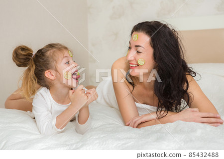 Mother and her daughter playing and hugging in the bed. Happy loving family. Happy mother's day. 85432488