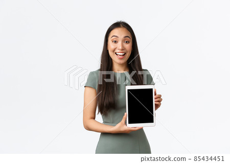 Enthusiastic happy asian female entrepreneur present new application. Businesswoman showing her online store. Small business owner show digital tablet screen and smiling amazed 85434451