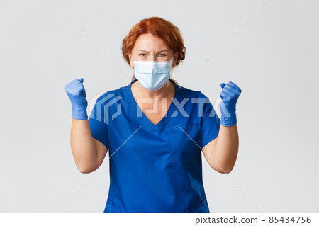 Medical workers, covid-19 pandemic, coronavirus concept. Upset and disappointed female doctor looking tensed, pressured, waited for something, receive bad news, clenching fists in frowning displeased 85434756