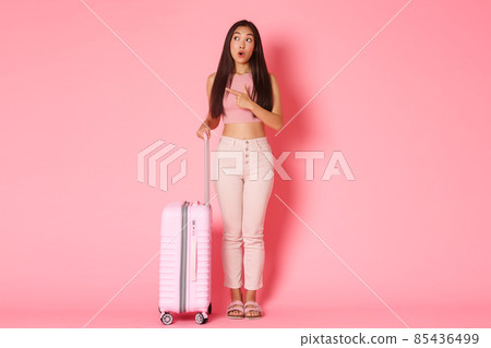 Travelling, holidays and vacation concept. Full-length of impressed and curious attractive asian girl tourist in summer outfit explore sightseeings, pointing left and look wondered, holding suitcase 85436499