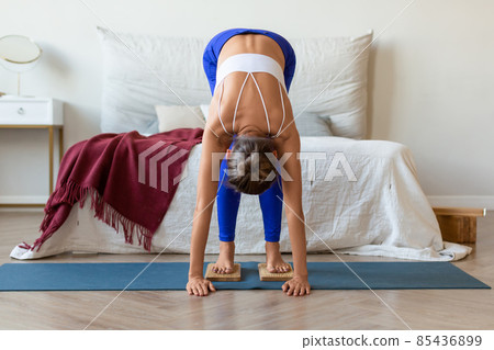 Middle-aged woman standing on a board with sharp nails. Sadhu's boards yoga practice. 85436899