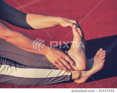 Bare foot mature woman stretching tendons and ankles 85437548