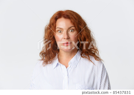 People, emotions and lifestyle concept. Close-up of surprised and speechless middle-aged pretty redhead woman react to shocking news, raising eyebrows and stare at camera wondered People, emotions and lifestyle concept. Close-up of surprised and speechless middle-aged pretty redhead woman react to shocking news, raising eyebrows and stare at camera wondered 85437831