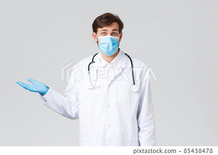 Hospital, healthcare workers, covid-19 treatment concept. Confused and clueless doctor in medical mask, gloves and scrubs, shrugging, spread hands sideways and look puzzled camera, feel unsure Hospital, healthcare workers, covid-19 treatment concept. Confused and clueless doctor in medical mask, gloves and scrubs, shrugging, spread hands sideways and look puzzled camera, feel unsure 85438478