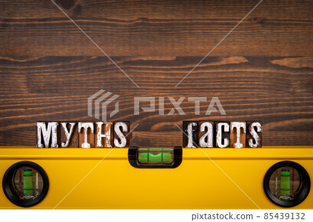 Myths and Facts Balance concept. Yellow spirit level on a wooden background 85439132