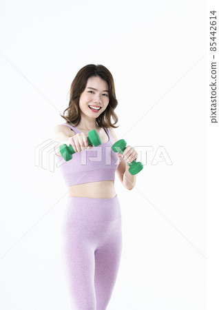 Female dumbbell punch training smile looking at the camera Female dumbbell punch training smile looking at the camera 85442614