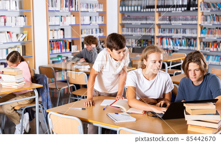 Teenage boys and girls in library Teenage boys and girls in library 85442670
