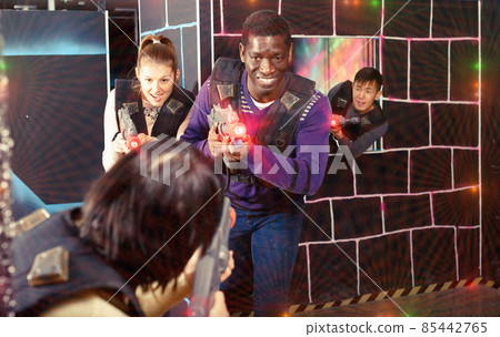 Modern people of different nationalities with laser pistols play Modern people of different nationalities with laser pistols play 85442765