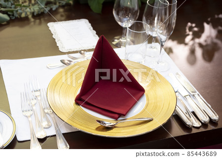 Table set with crimson napkins Table set with crimson napkins 85443689