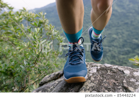 Successful hiker climbing rock to mountain top cliff edge 85448224