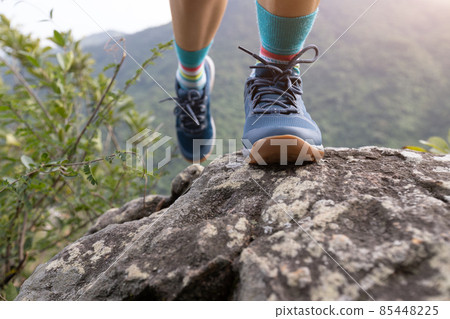 Successful hiker climbing rock to mountain top cliff edge Successful hiker climbing rock to mountain top cliff edge 85448225
