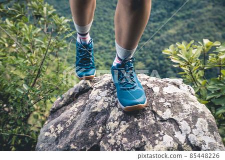 Successful hiker climbing rock to mountain top cliff edge Successful hiker climbing rock to mountain top cliff edge 85448226
