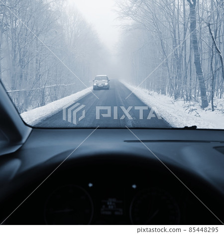 Driving the car in the winter. View from the interior of a car on a snowy road by the eyes of the driver. Concept for driving safety in the winter. 85448295