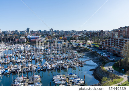 BC, Canada - April 4 2021 : Granville Island Marina Fishermens Wharf Float. Vancouver city buildings skyline. 85449889