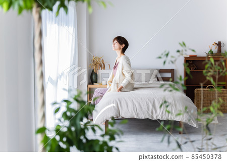 一個女人坐在床上 85450378