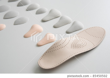 Orthopedic insole on a white background. Treatment and prevention of flat feet and foot diseases. Foot care, foot comfort. Wear comfortable shoes. Orthopedic insole on a white background. Treatment and prevention of flat feet and foot diseases. Foot care, foot comfort. Wear comfortable shoes. 85450502