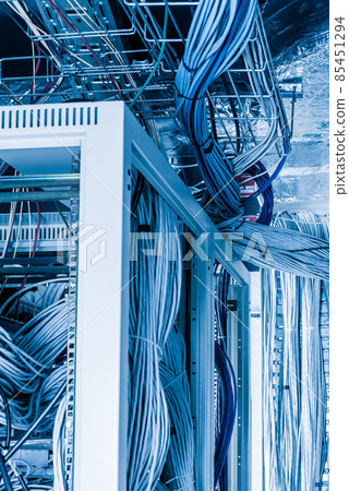bunch of network cables in wave pattern leading across server ro 85451294