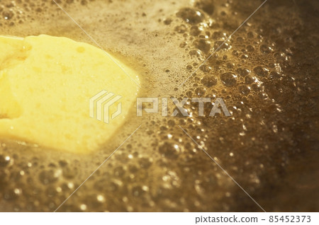 Piece of butter melting on non-stick frying pan 85452373