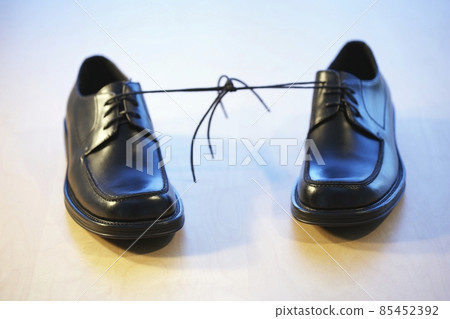 Pair of black man shoes tied together Pair of black man shoes tied together 85452392